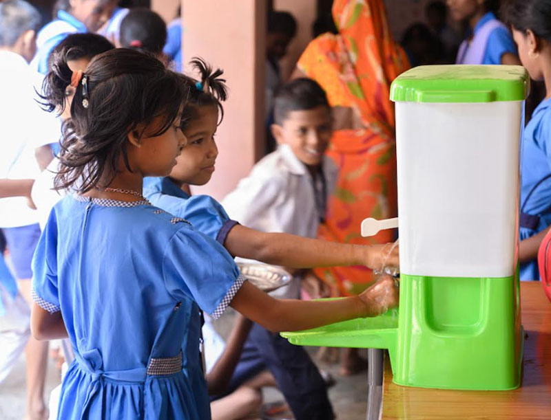 Children in AWC, Purushottampur washing their hands on portable handwashing station HappyTap.